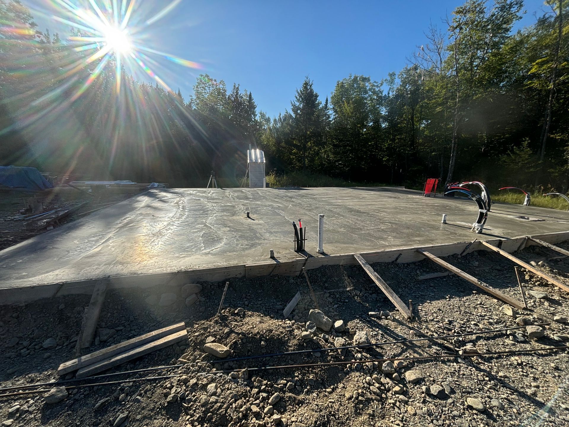 The sun is shining through the trees on a construction site.