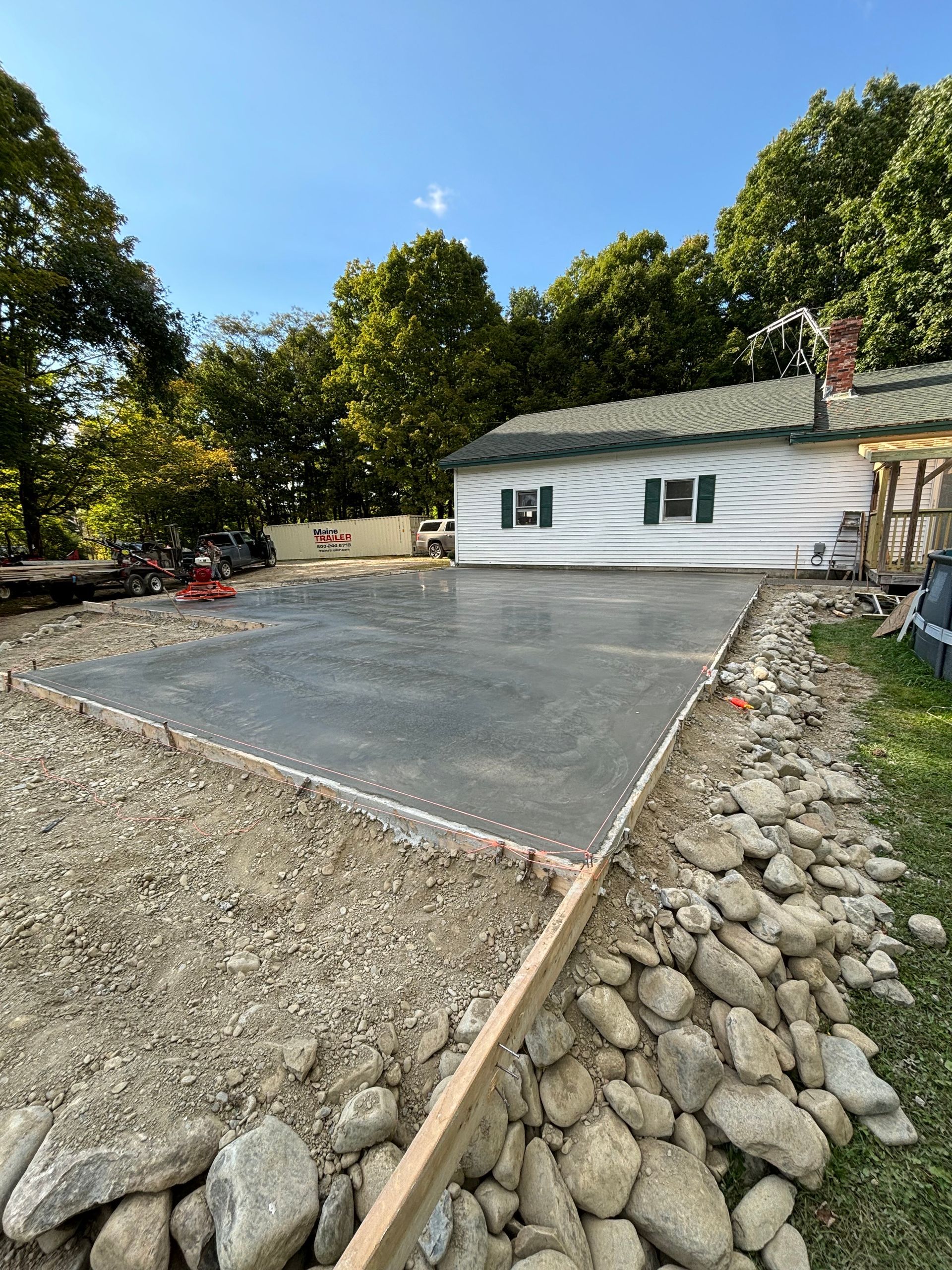 A concrete driveway is being built in front of a house.