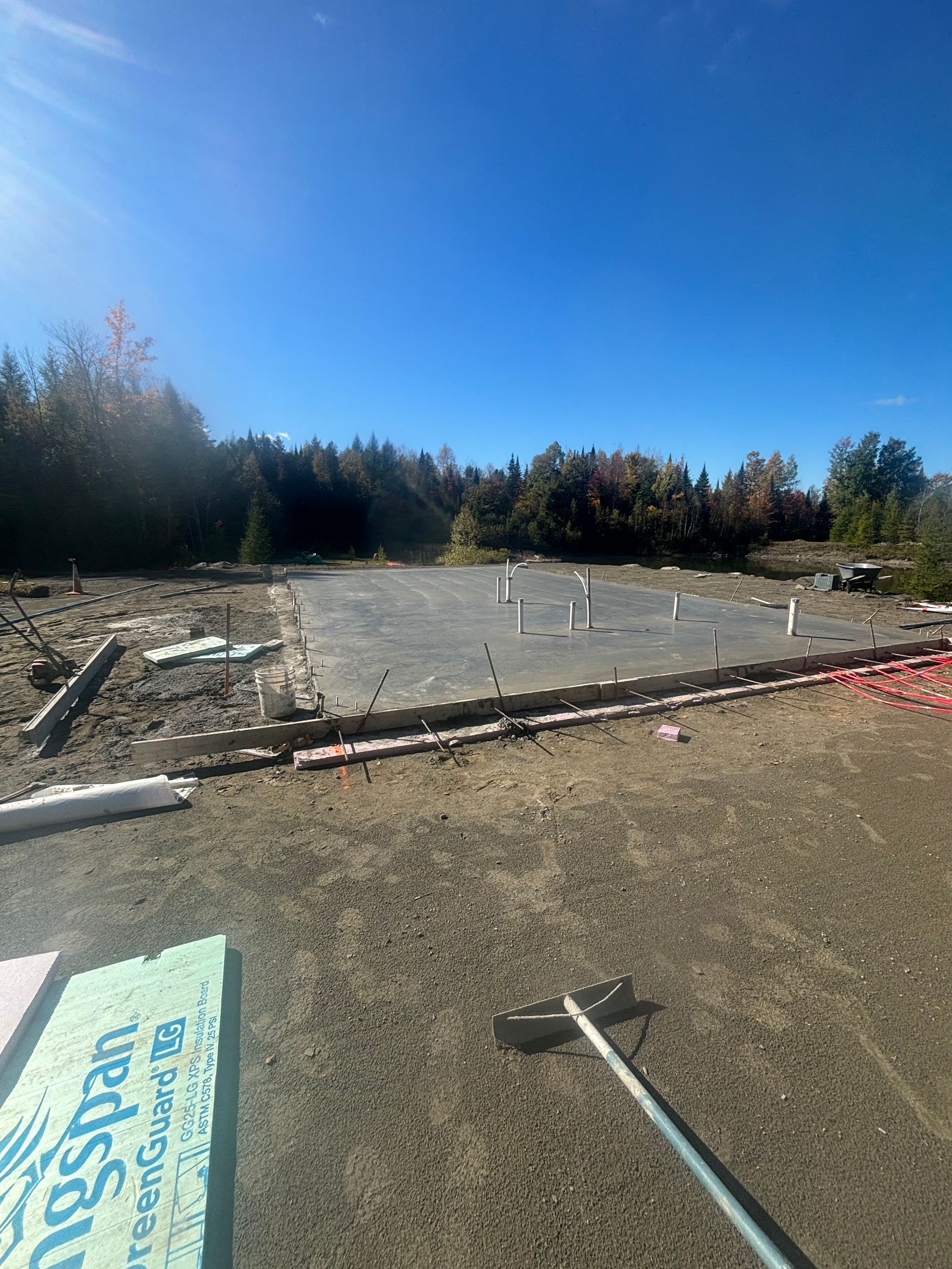 A concrete foundation is being built in a dirt field.