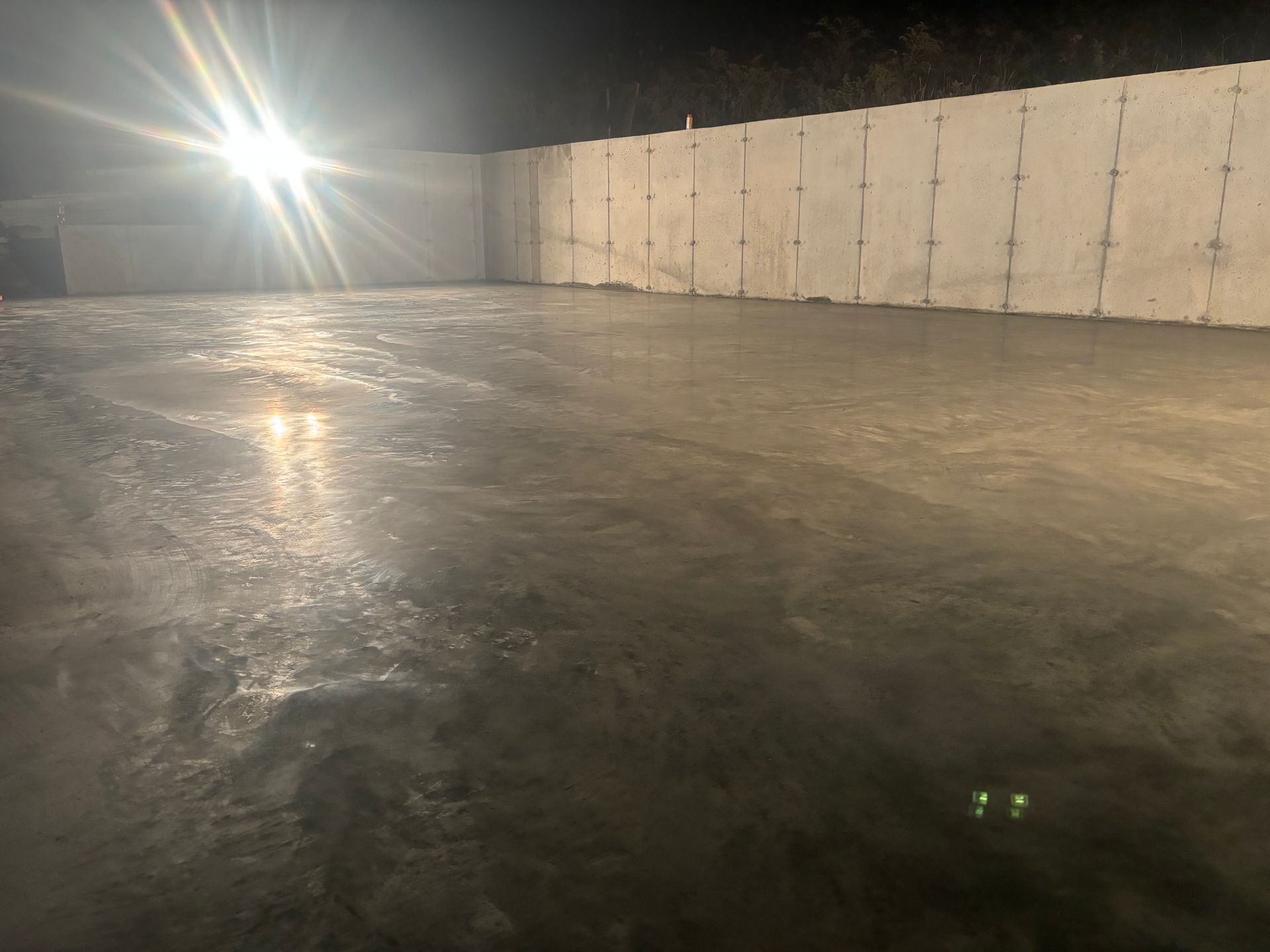 A concrete floor with a light shining on it at night.