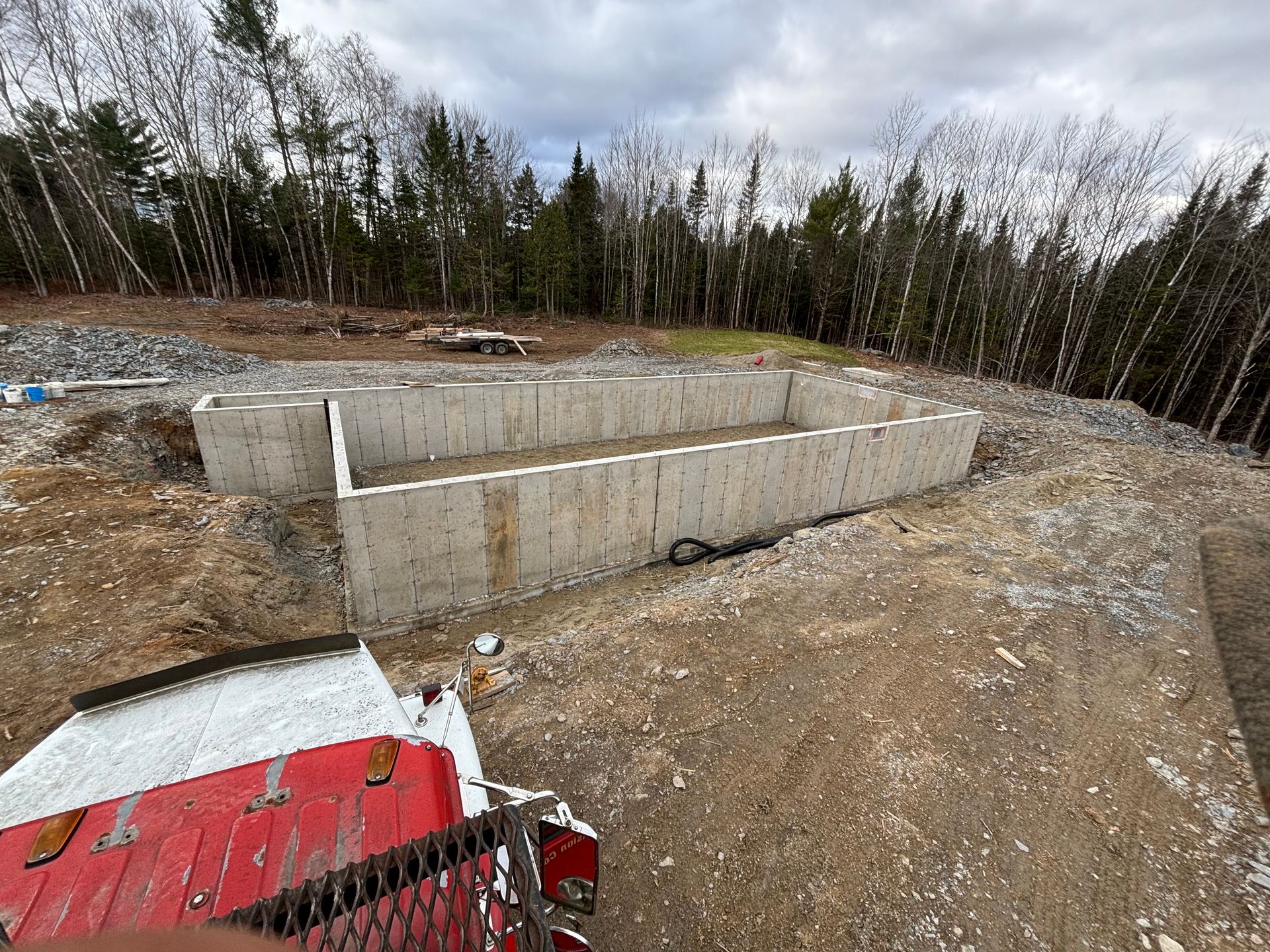 A concrete foundation is being built in the middle of a dirt field.