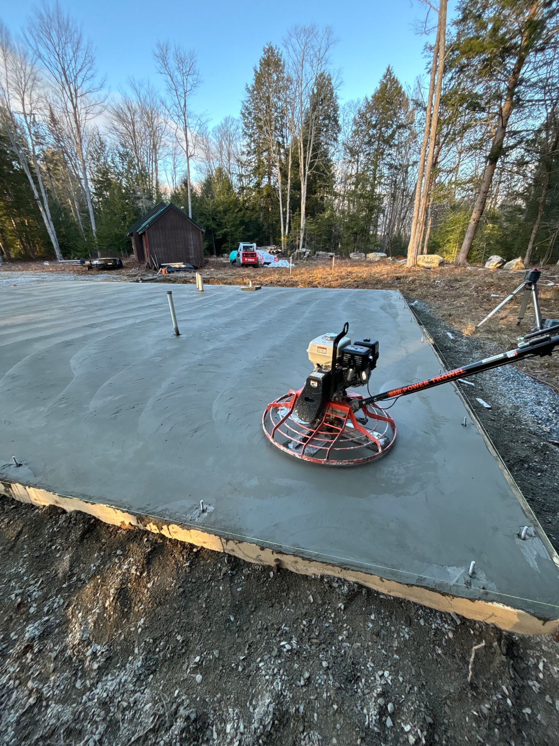 A concrete trowel is sitting on top of a concrete slab.