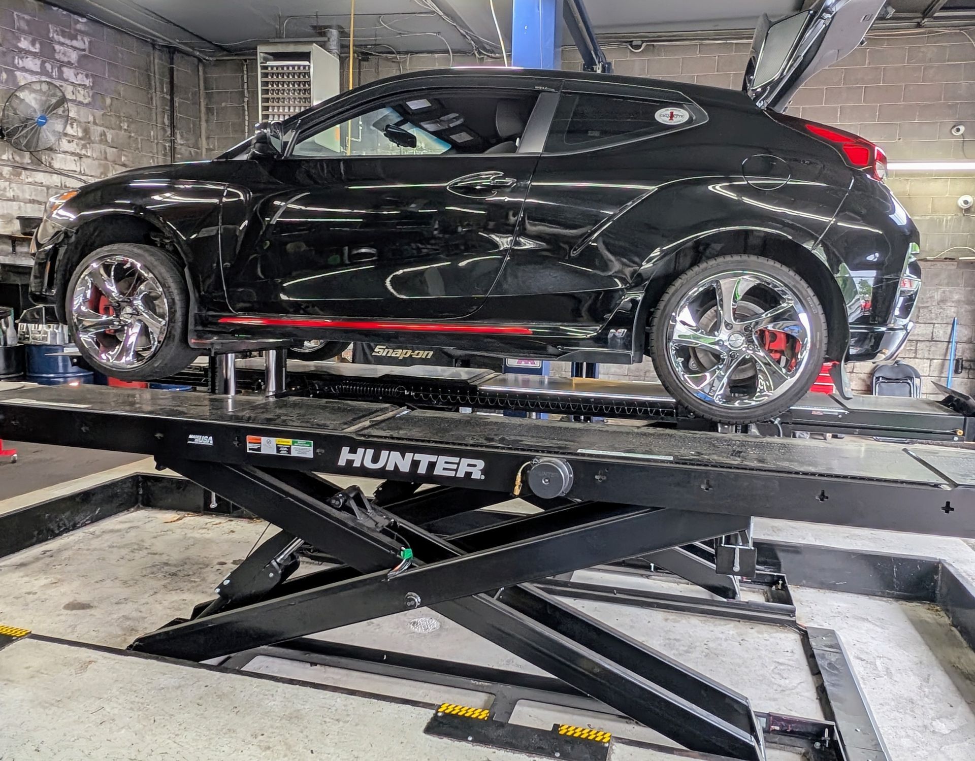 Hyundai Veloster N safely elevated on low-profile scissor lift at Dee Pat’s Awsomotive