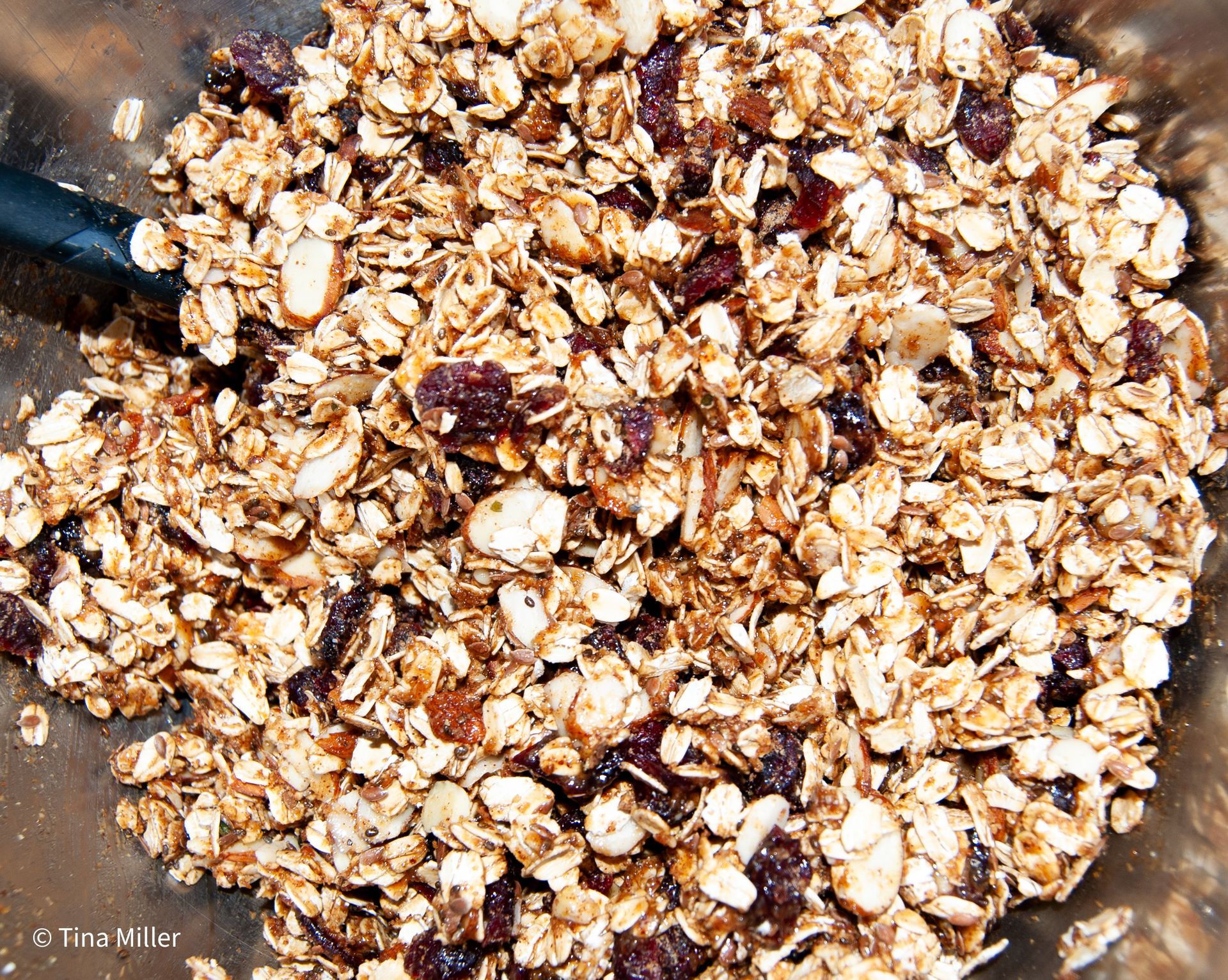 A granola mixture with an almond butter glaze ready to be baked.