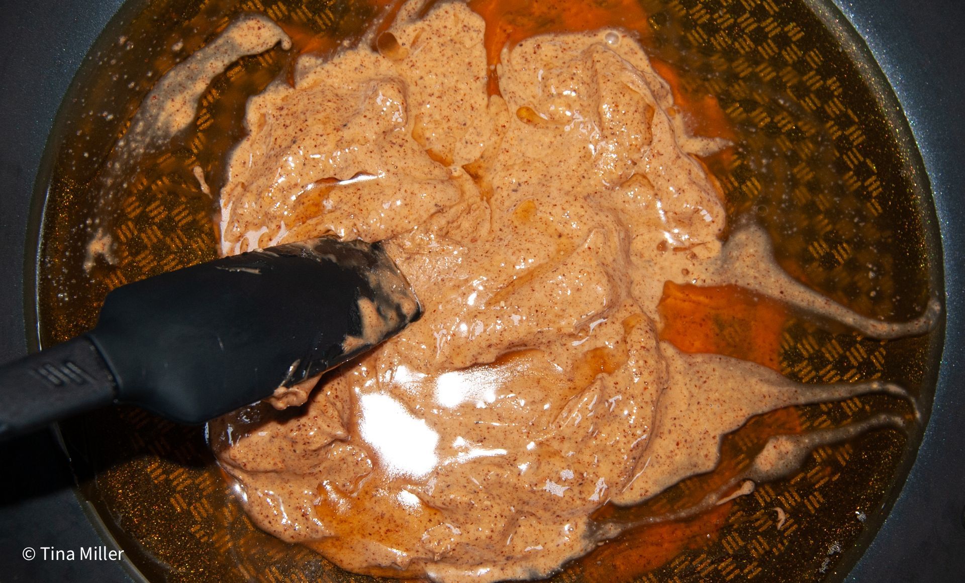 Almond butter, agave, and vanilla extract in a pan melting over medium heat.
