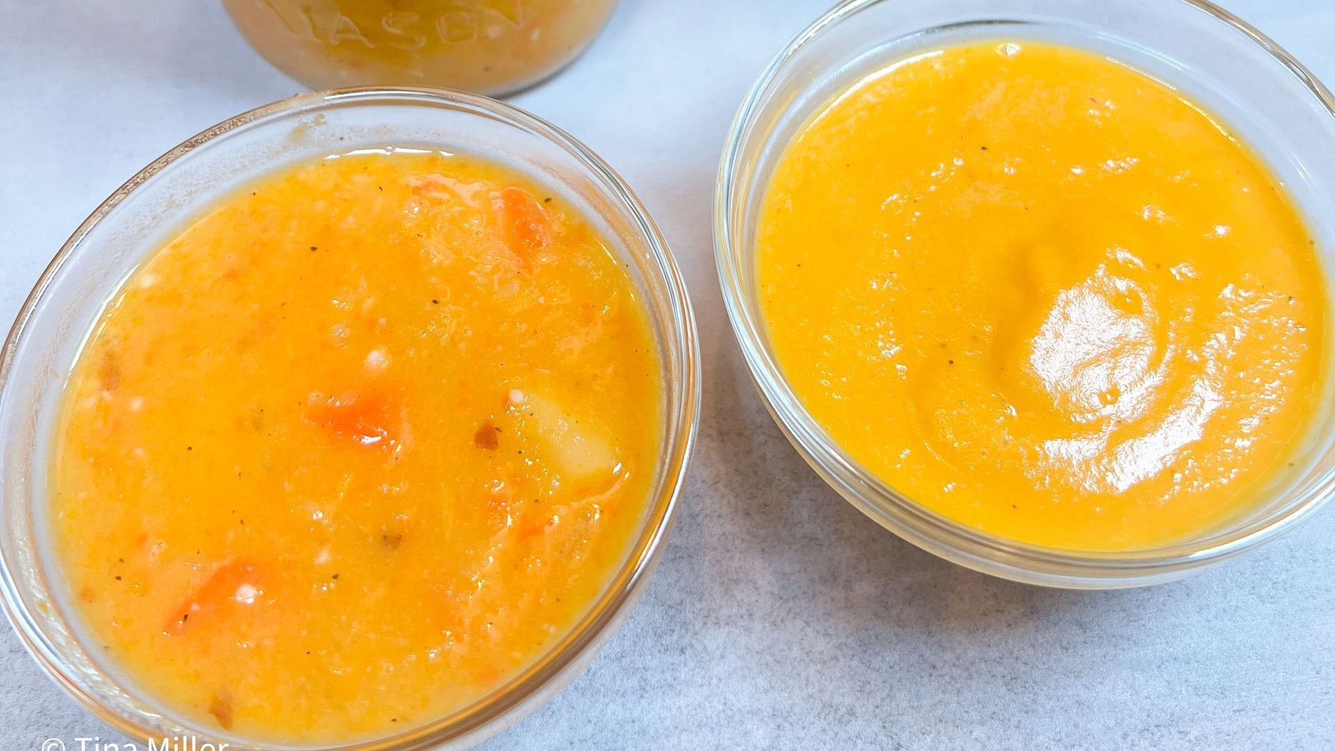 two small glass bowls side-by-side of roasted butternut squash bisque showing comparison of chunkier immersion blender verses smoother traditional blender finishing.