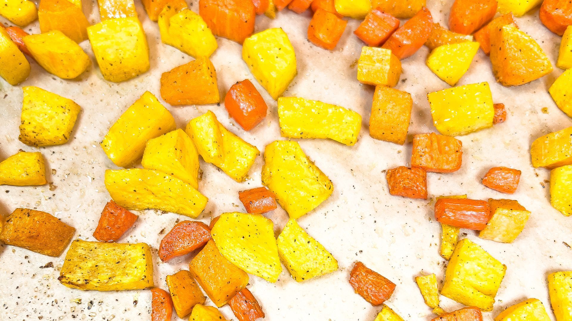Roasted candy squash, butternut squash, and carrots on parchment paper.