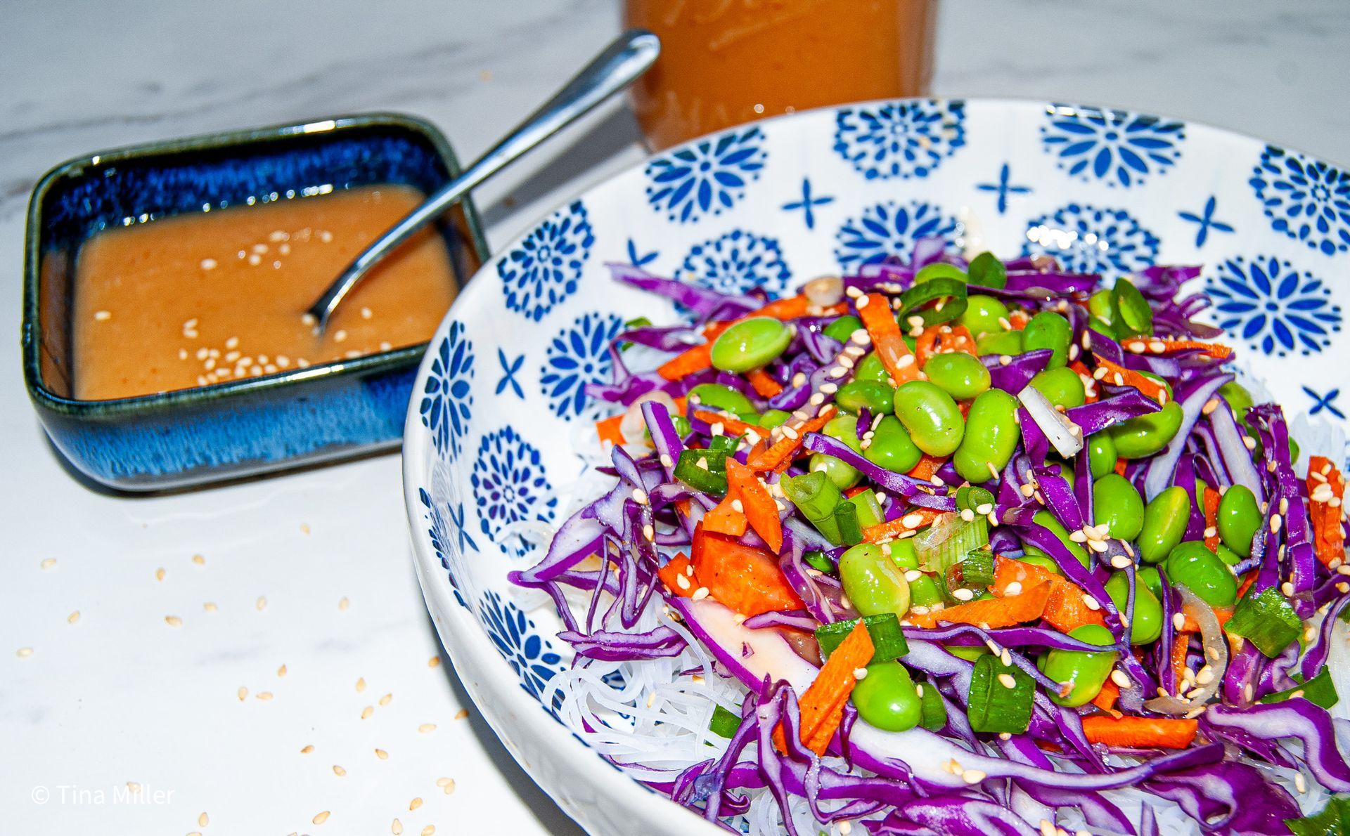 Red cabbage and shelled edamame slaw with carrots over rice vermicelli, with miso dressing.