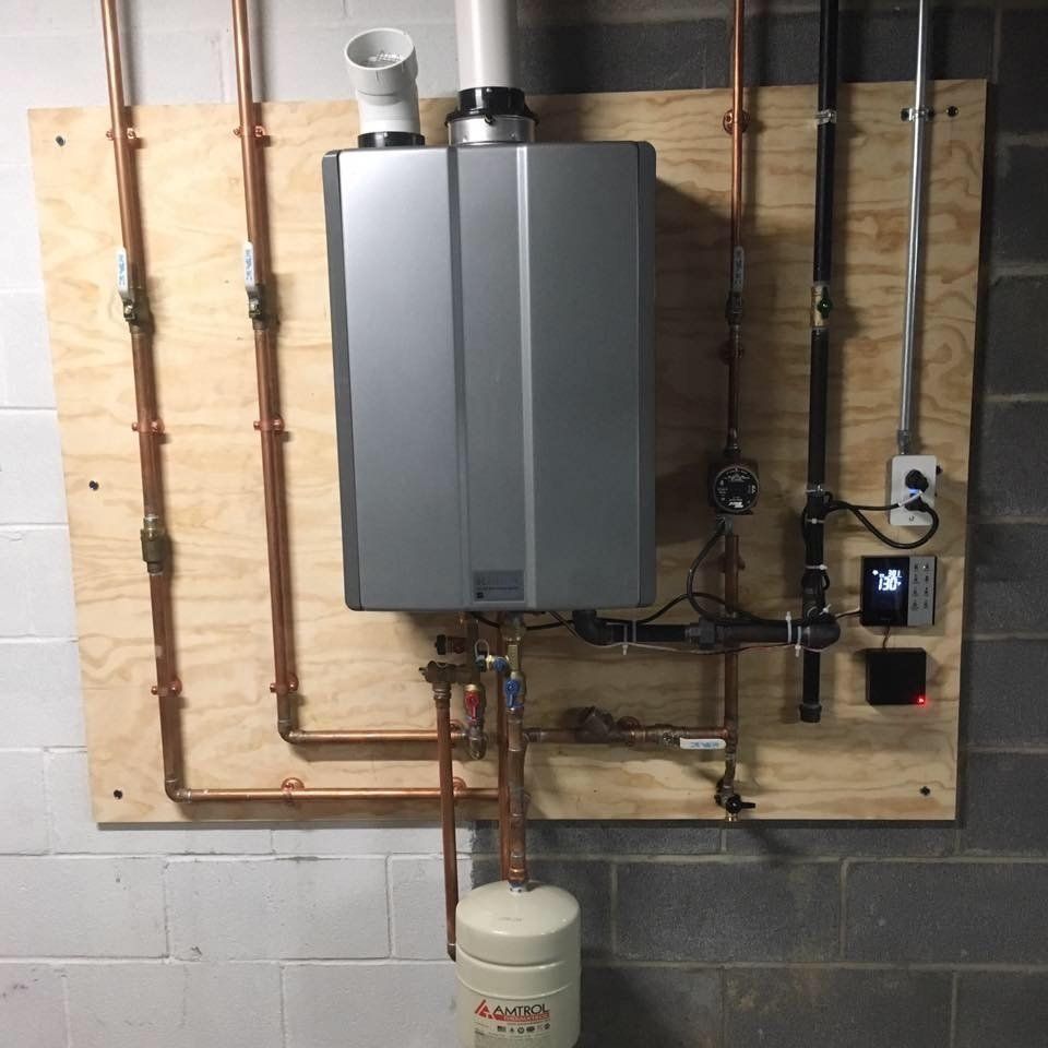 The image displays a professionally installed Rinnai gas tankless water heater system. 