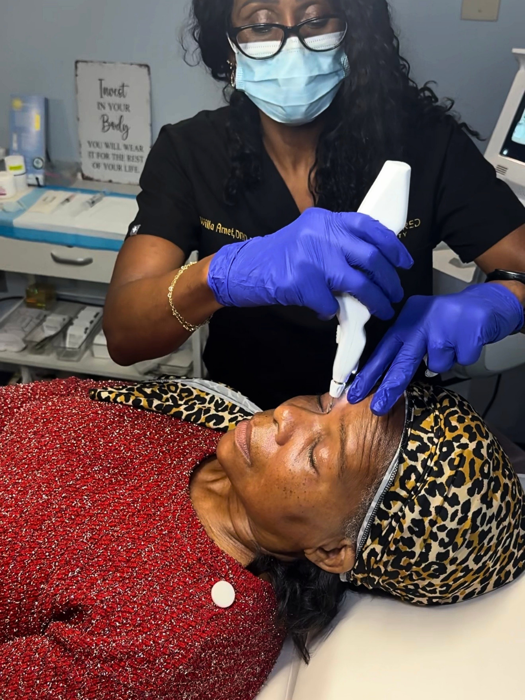 A professional uses a medical device on a person’s forehead in a clinic setting.
