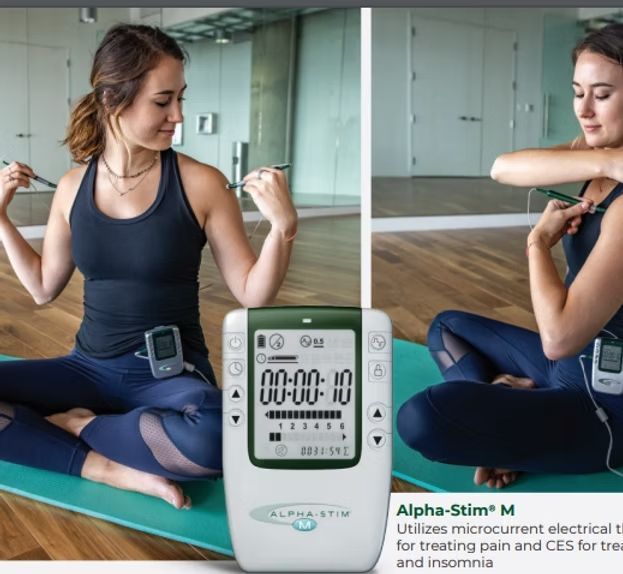Woman using Alpha-Stim device, sitting in a yoga pose.