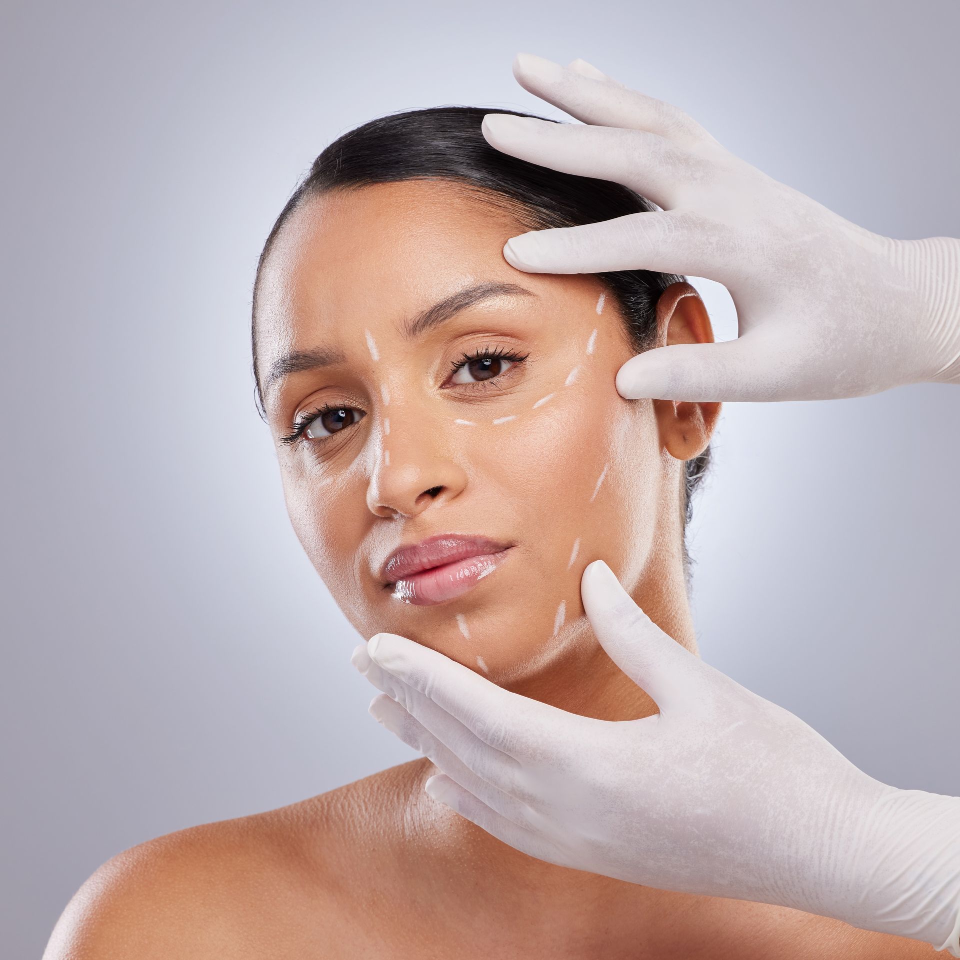 A professional uses a medical device on a person’s forehead in a clinic setting.
