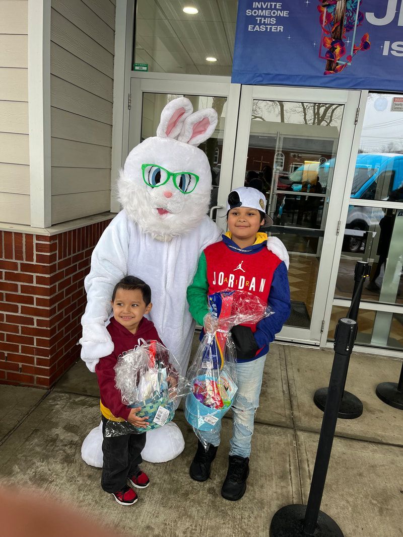 Two young boys are standing next to a white bunny mascot.
