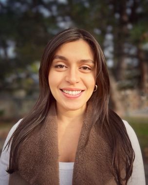 A woman wearing a brown scarf is smiling for the camera