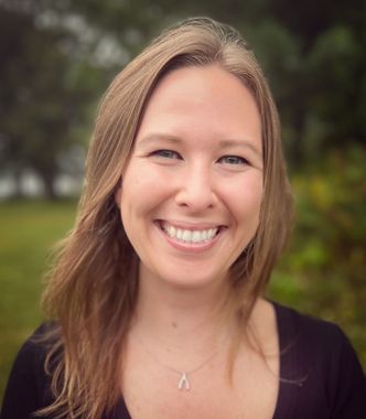 A young woman with long hair is smiling for the camera.