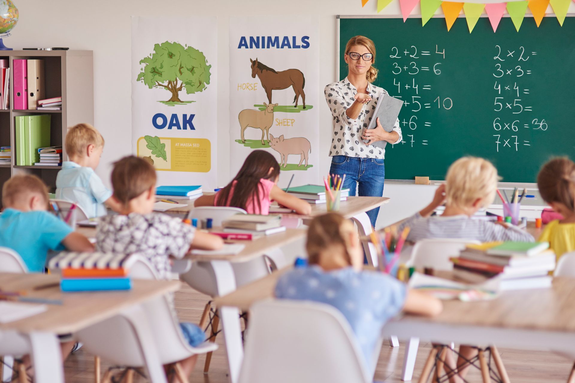 A teacher is teaching a group of children in a classroom.