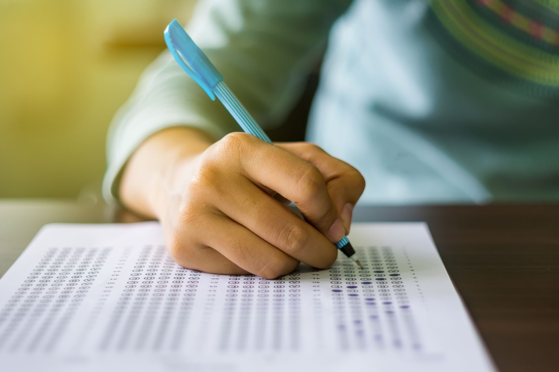 A person is writing on a piece of paper with a pen.