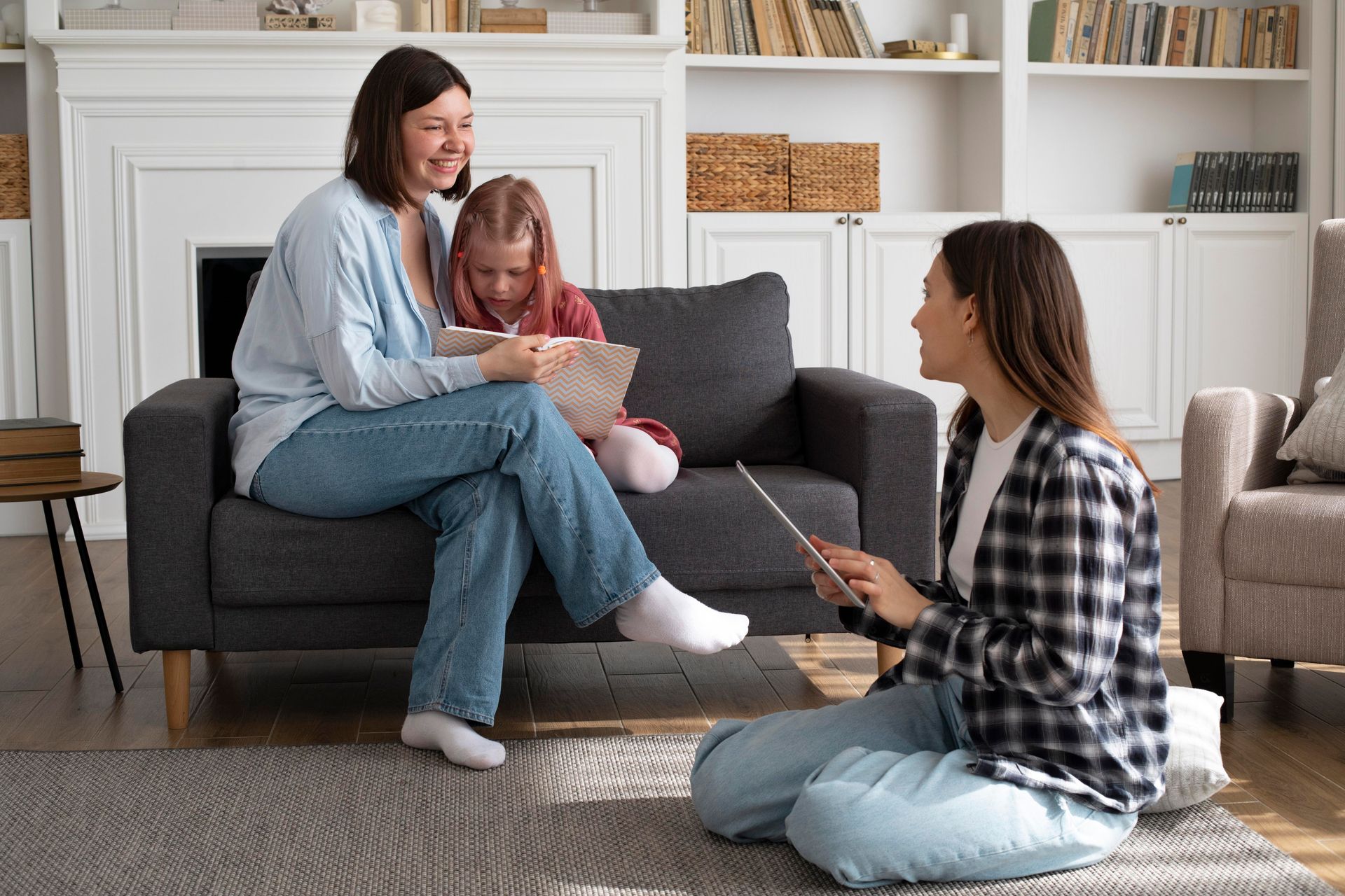 A woman is sitting on a couch talking to a little girl.