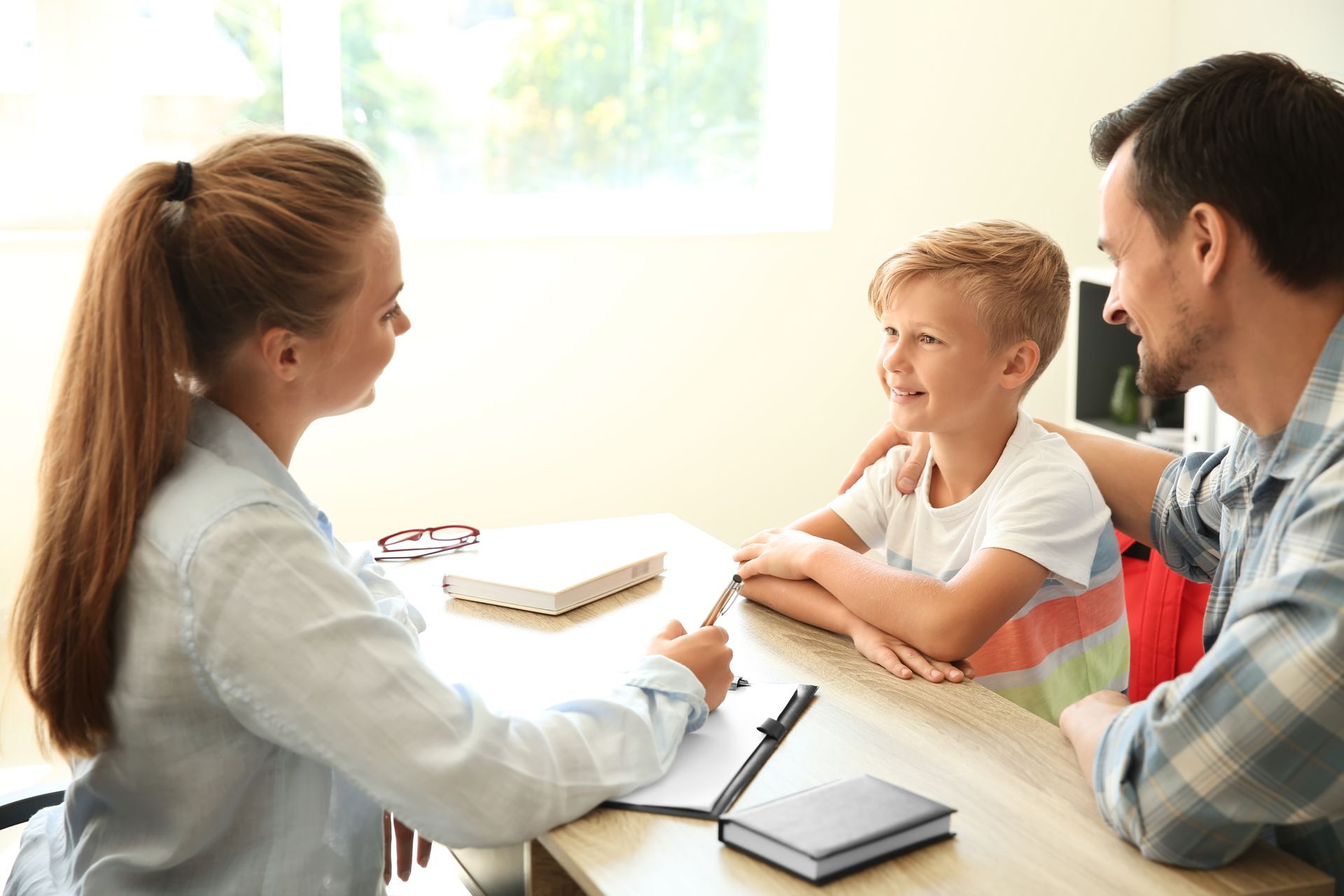 A woman is sitting at a table with a man and a child.