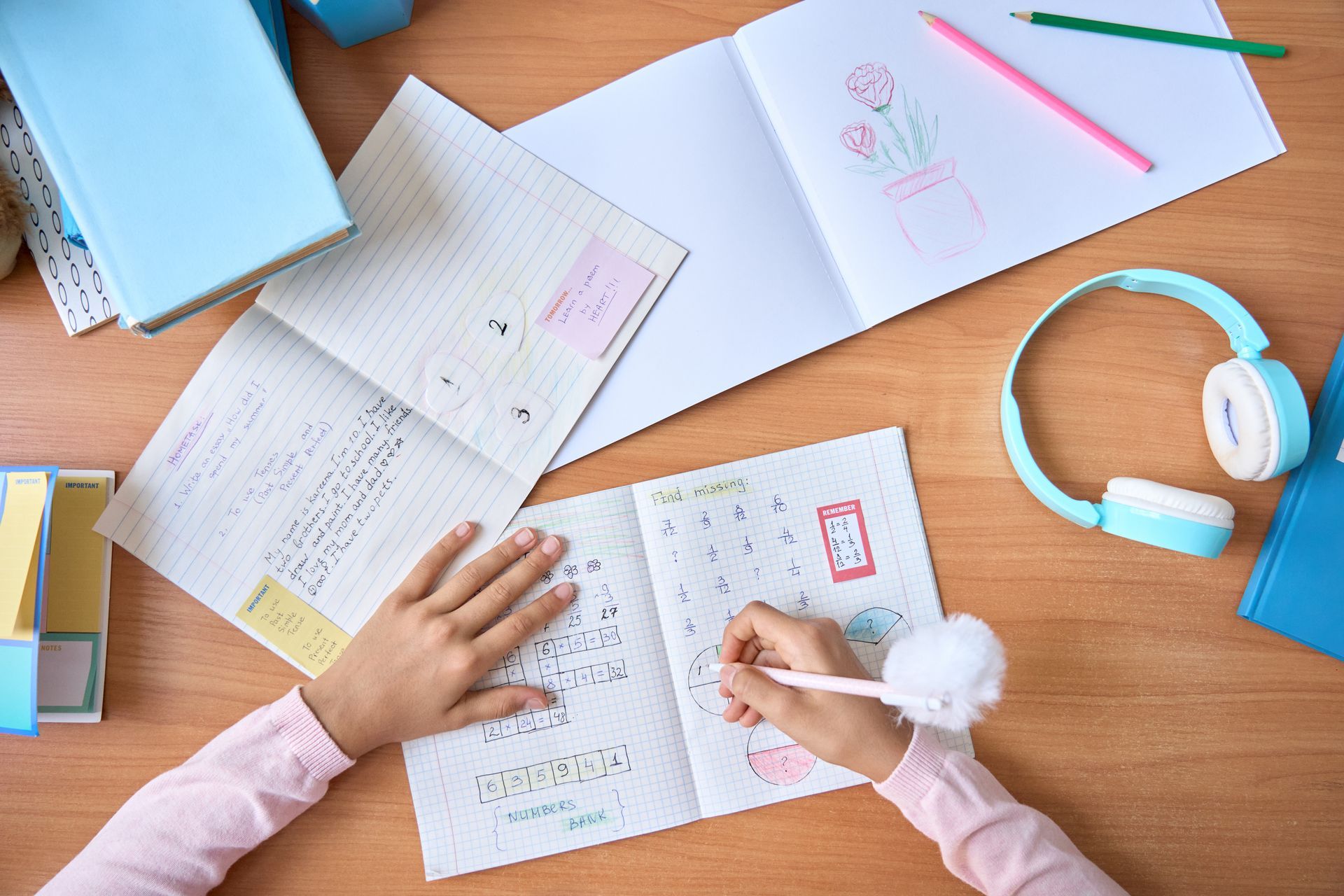 A child is sitting at a desk writing in a notebook.