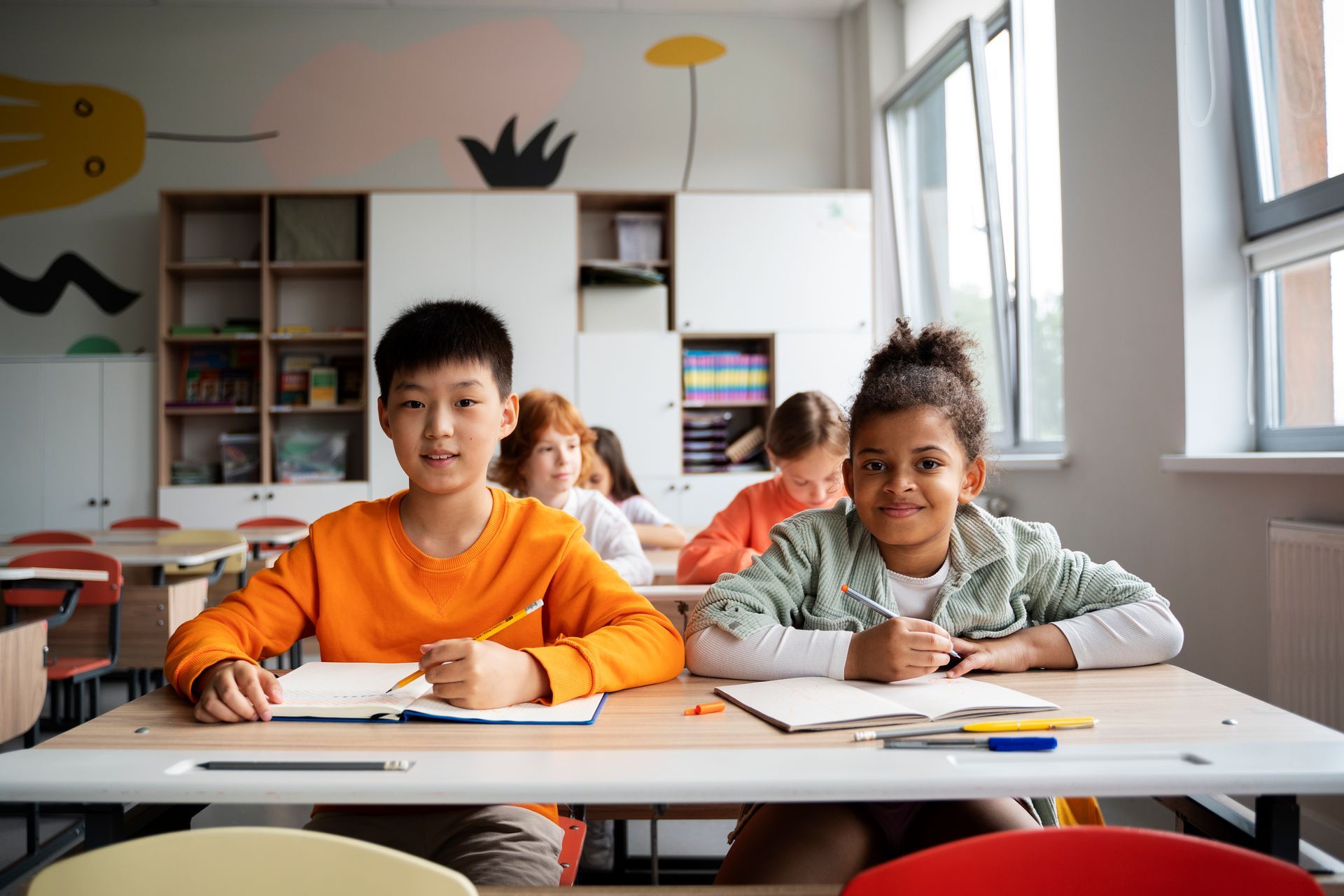 A group of children are sitting at their desks in a classroom.