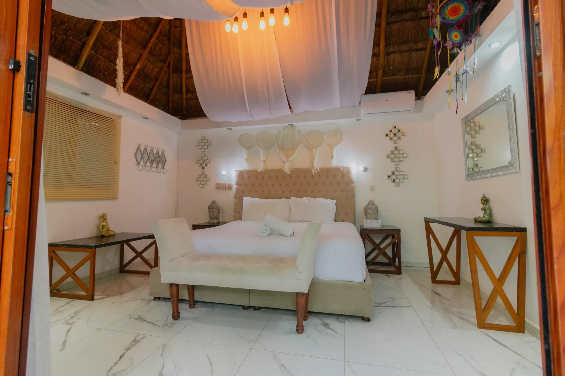 Acogedora habitación con cama con dosel, luces de guirnalda cálidas y detalles decorativos de madera.