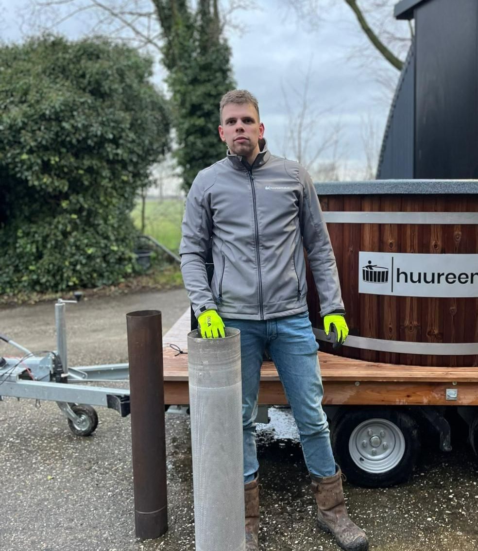 Een man staat naast een aanhanger met daarop een hottub.
