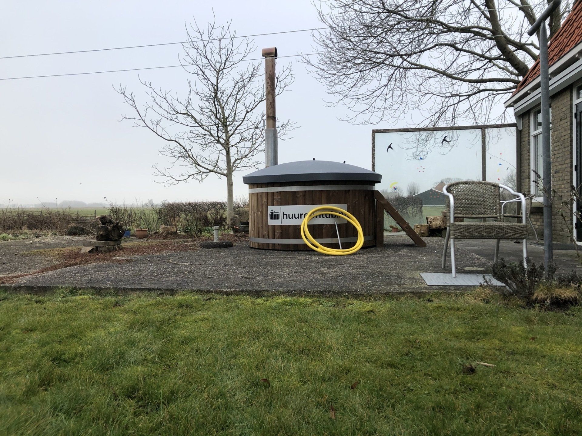 Er staat een hottub in het gras voor een huis.