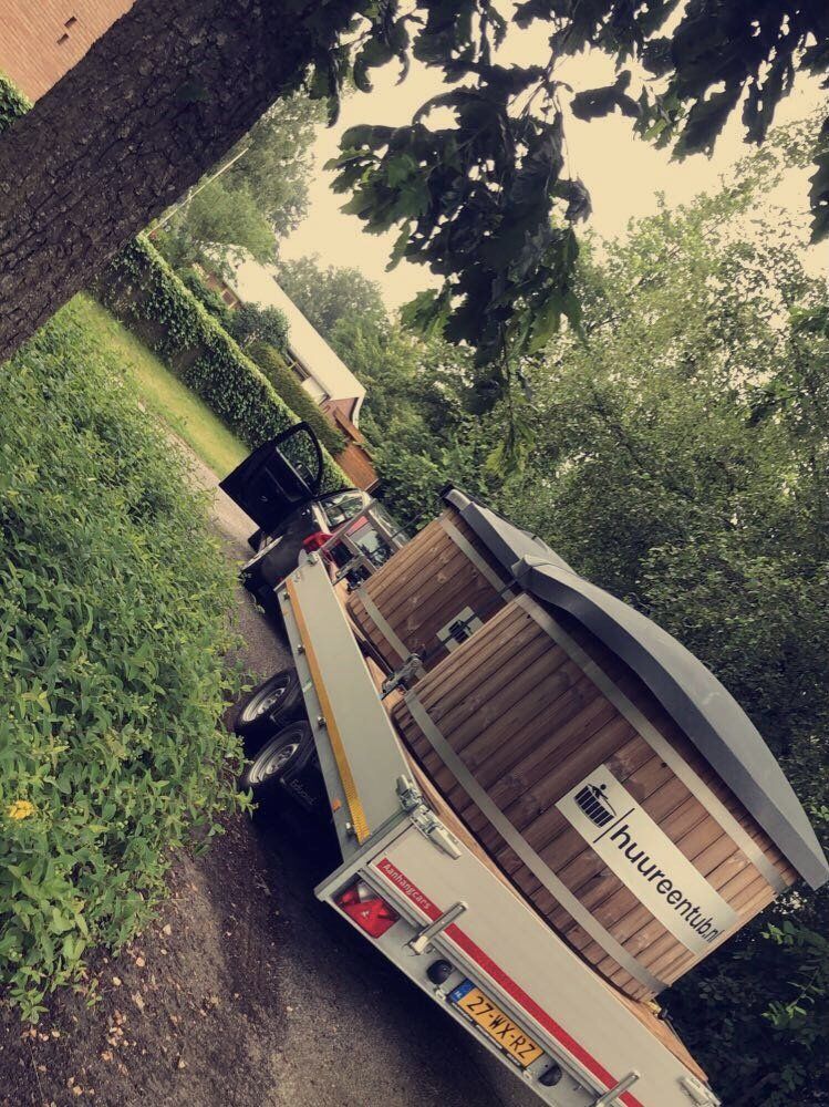 Een aanhanger met twee hot tubs met logo erop. 