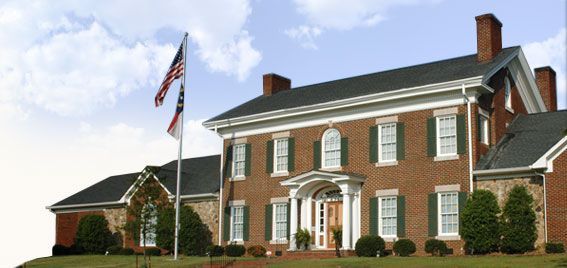 A large brick house with a flag in front of it