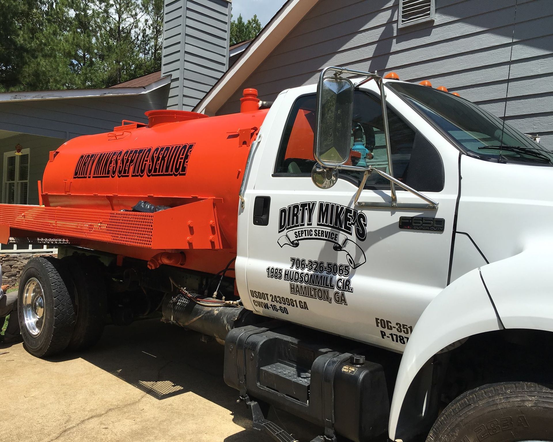 A white truck with an orange tank that says rat busters on it