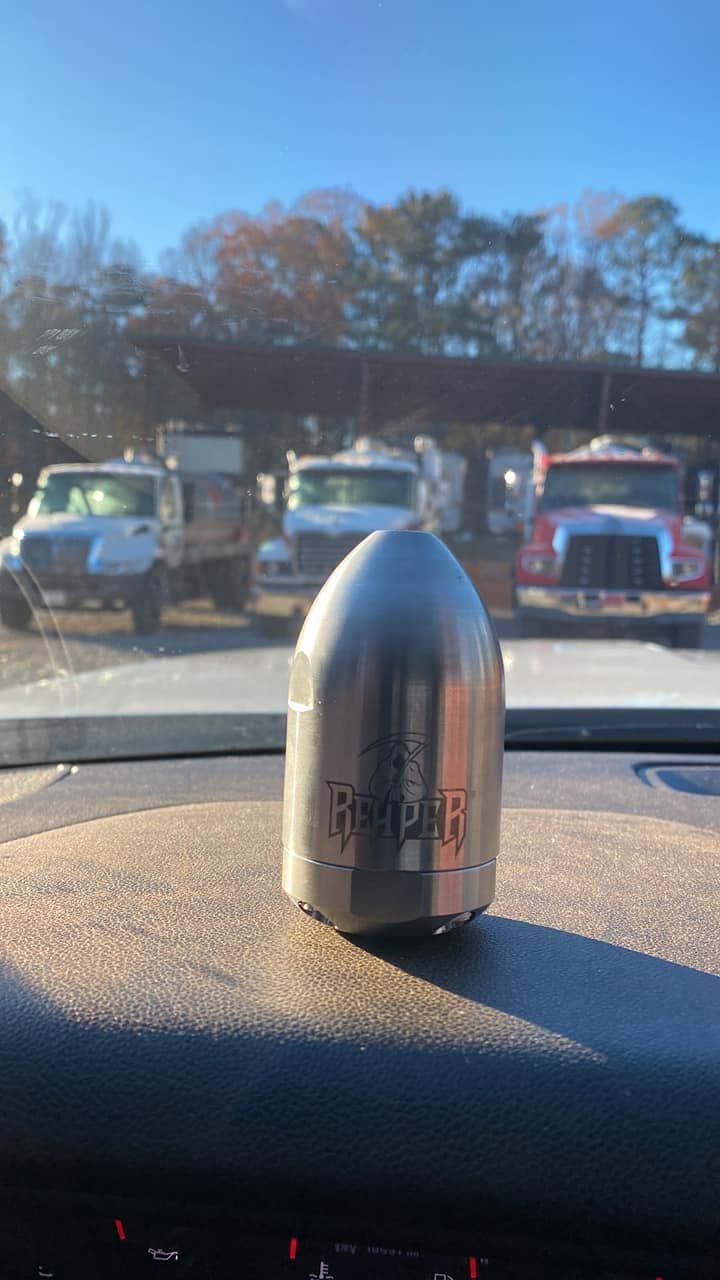 A metal object is sitting on the dashboard of a car.