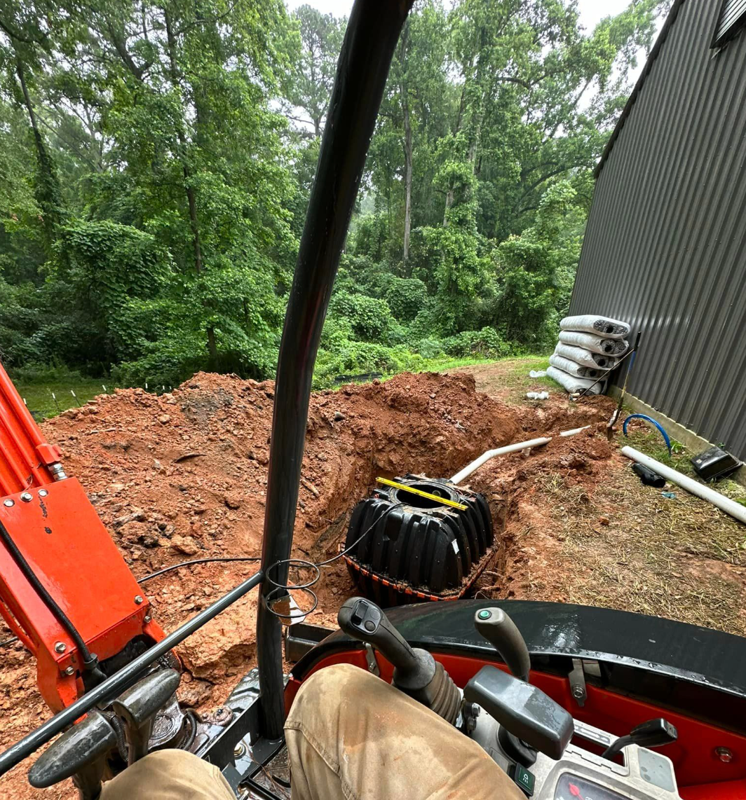 A black pipe is sitting in the middle of a hole in the ground.