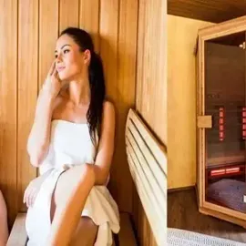 Woman sitting in a wooden sauna, resting beside a heated stove with glowing elements