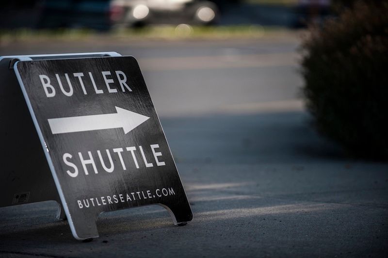 A black A-frame sign on a sidewalk reads 