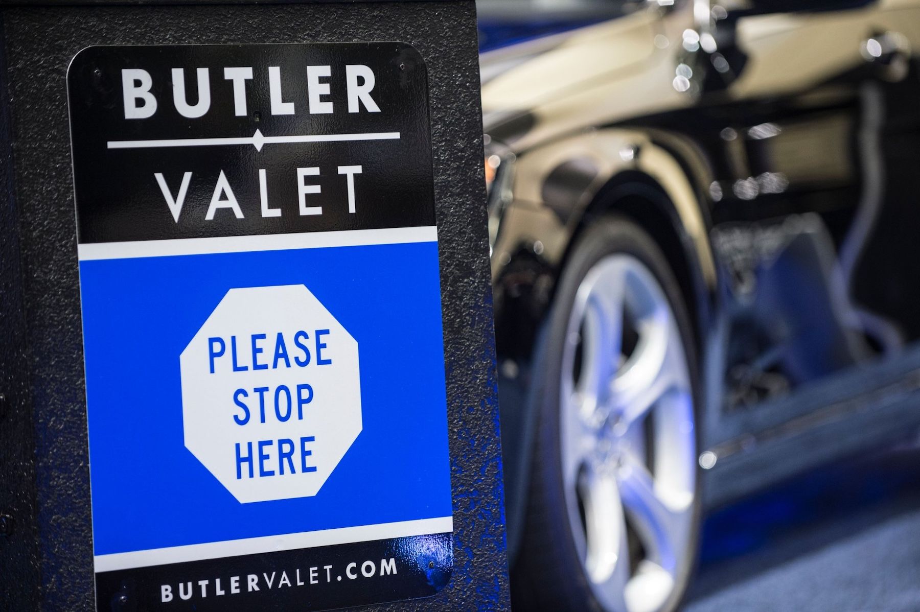 A close-up of a blue and black Butler Valet sign that reads 