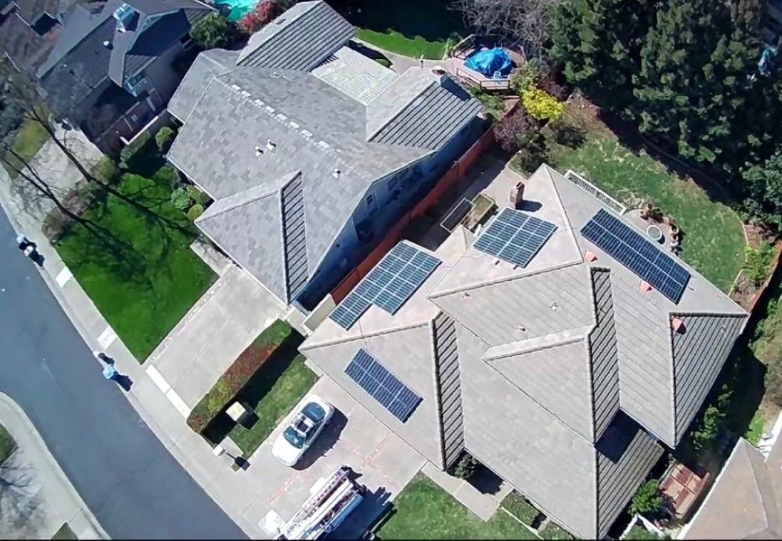 An aerial view of a house with solar panels on the roof