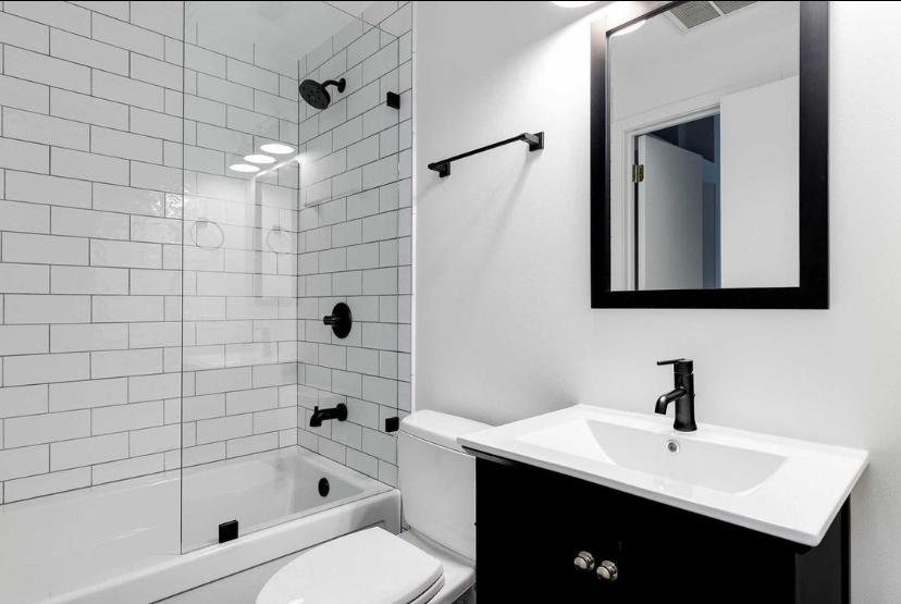 A bathroom with a sink , toilet , shower and mirror.