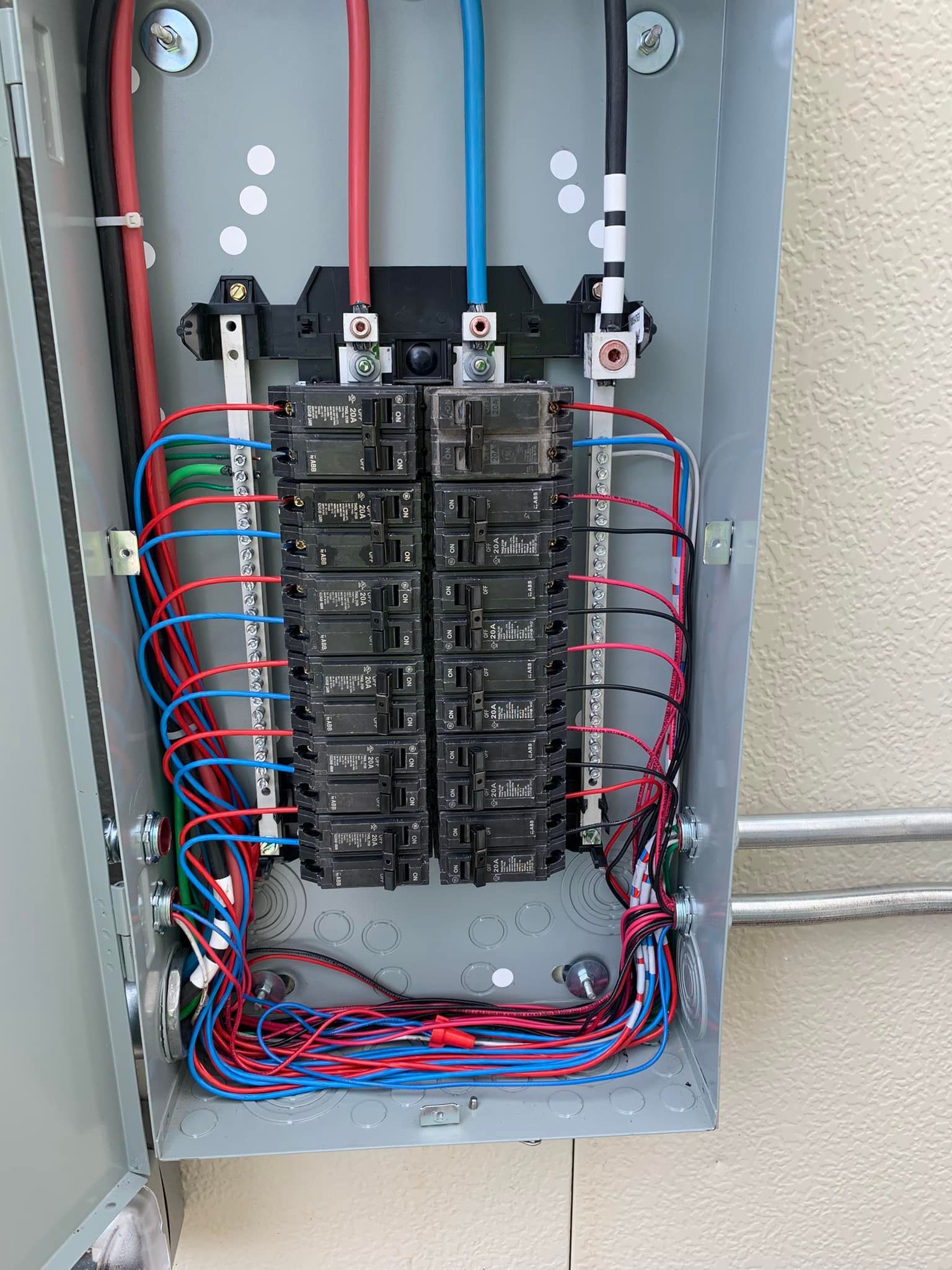 A close up of a electrical box with a lot of wires coming out of it.