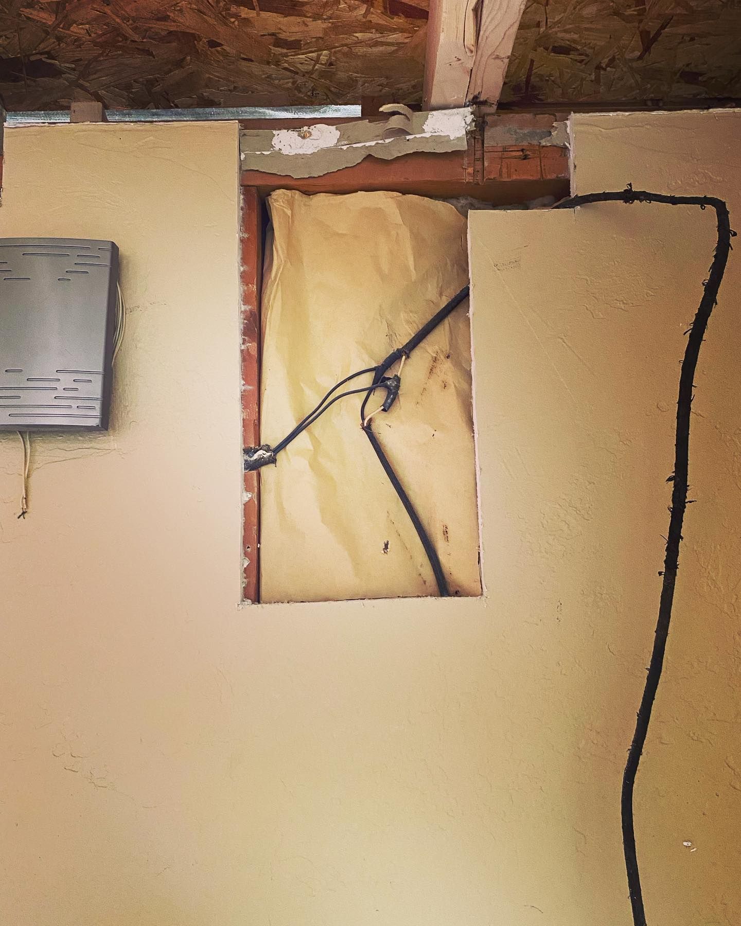 A hole in a wall with a wire coming out of it