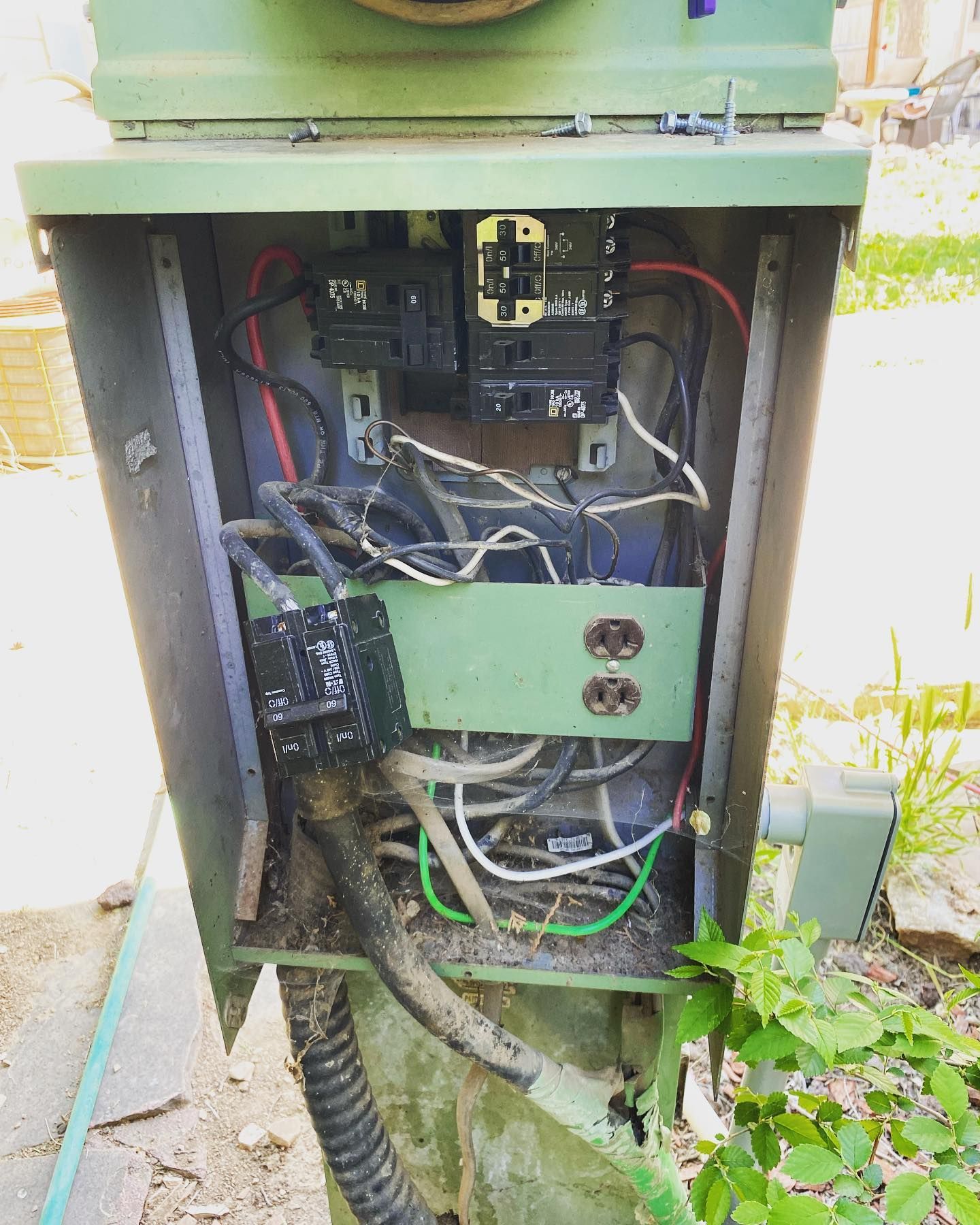 A green box with a lot of wires coming out of it.
