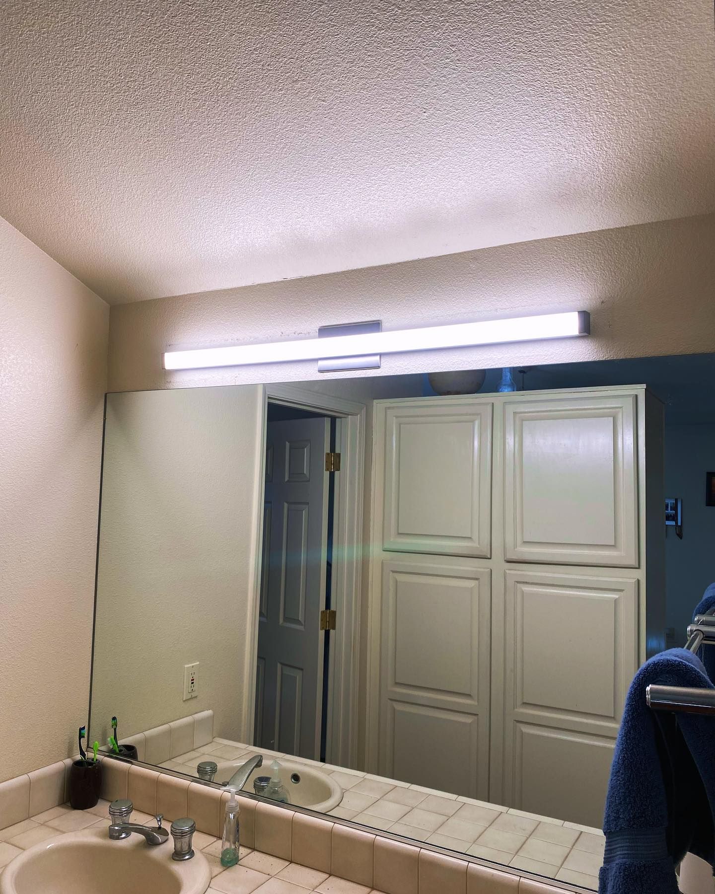 A bathroom with a large mirror and a sink