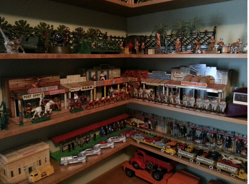 Corner shelves displaying collections of vintage toy western buildings, miniature figures, and model vehicles.