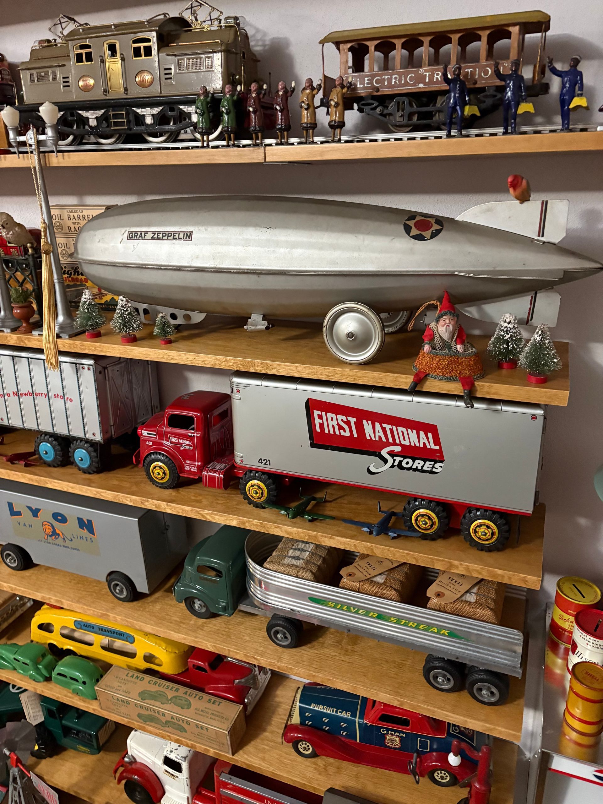 Shelves filled with toy trucks, trains, and a silver blimp model in a colorful display.