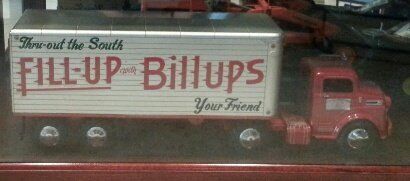 A miniature red semi-truck toy featuring a silver trailer with 