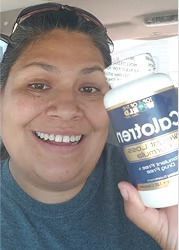Woman smiling, holding a bottle of Calcitren in a car.