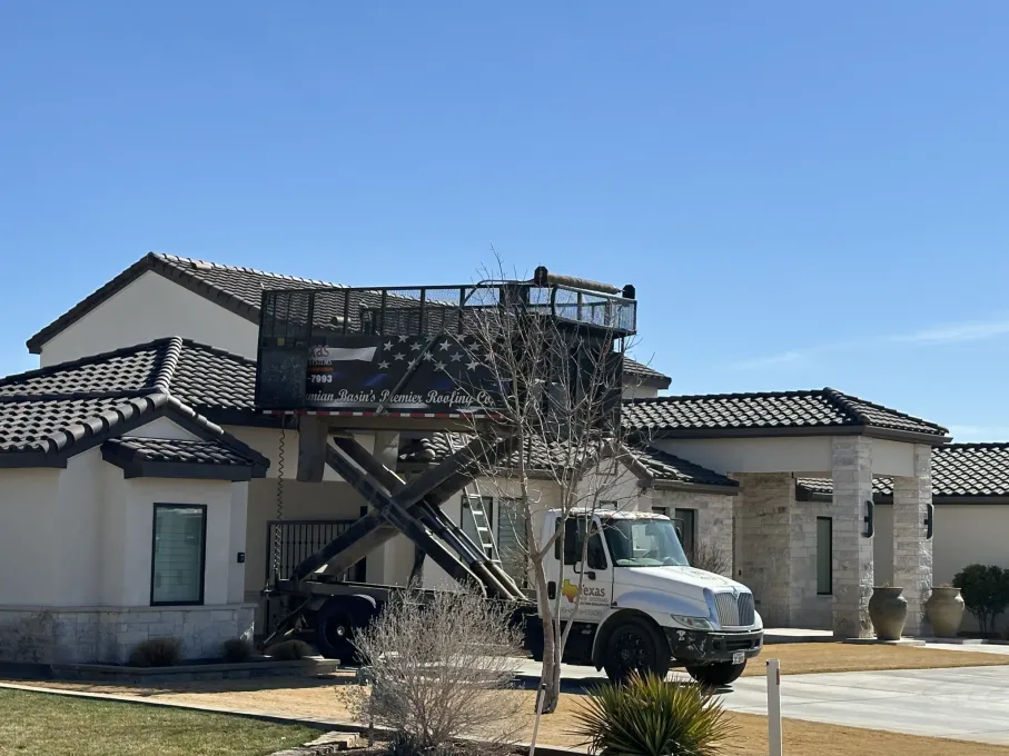 A white truck is parked in front of a large house.