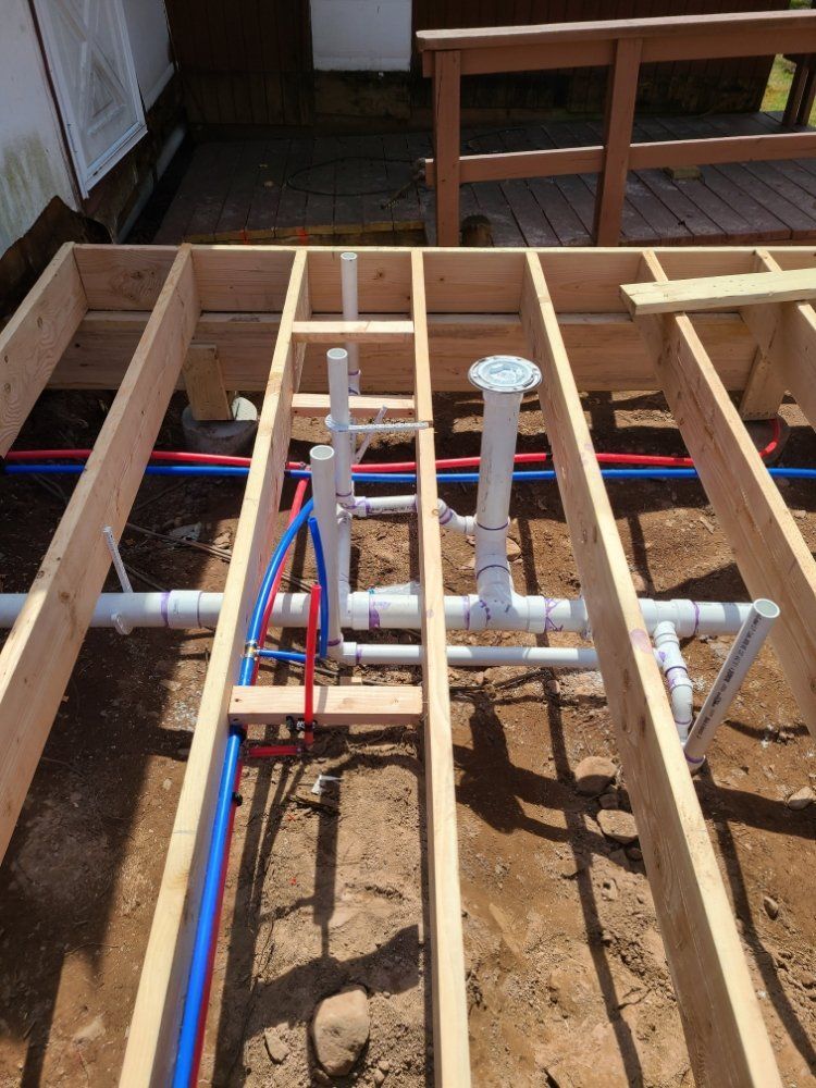 A wooden floor with a bunch of pipes going through it