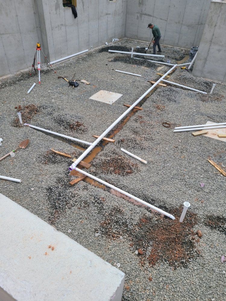 A man is standing on a gravel floor in a basement.