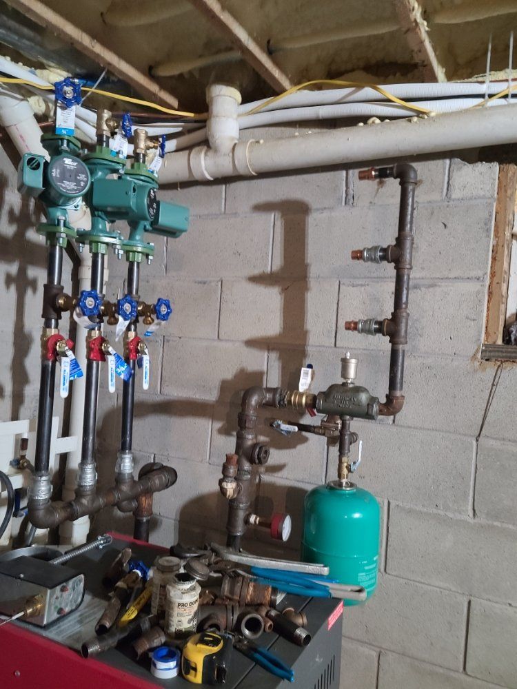 A room with a lot of pipes and valves on the wall